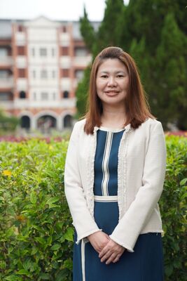 余婌禎 校長  這張圖片是一張這張圖片是一張余婌禎 校長肖像照，畫面中的女士氣質端莊優雅。肖像照，畫面中的女士氣質端莊優雅。人物特寫 形象： 畫面中的女士留著棕色的中長髮，面帶溫和親切的微笑。  穿著： 她身穿一件深藍色與白色條紋相間的連身裙，外面搭配一件米白色的編織質感小外套（香風外套），雙手自然交疊於身前，展現出專業且平易近人的師長或主管形象。